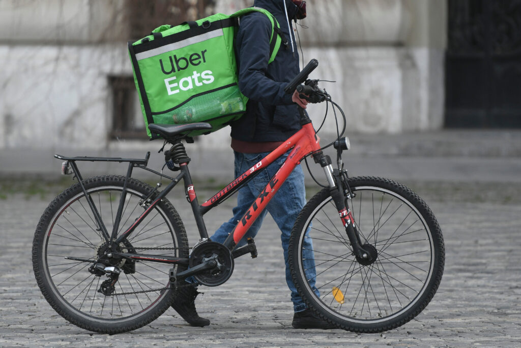 Bucharest, Romania - March 15, 2020: Man delivering food with Uber Eats service, due to isolation caused by coronavirus outbreak.