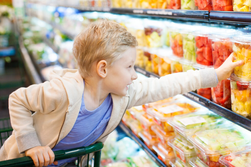 Little boy in grocery store reaching for container of fruit. 

Picture by Aleksei Potov.