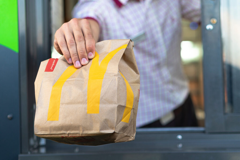 Sankt-Petersburg/Russia - July 21 2019: McDonald's worker holding bag of fast food. Hand with a paper bag through the window of mcdonalds car drive thru service.
By gargantiopa